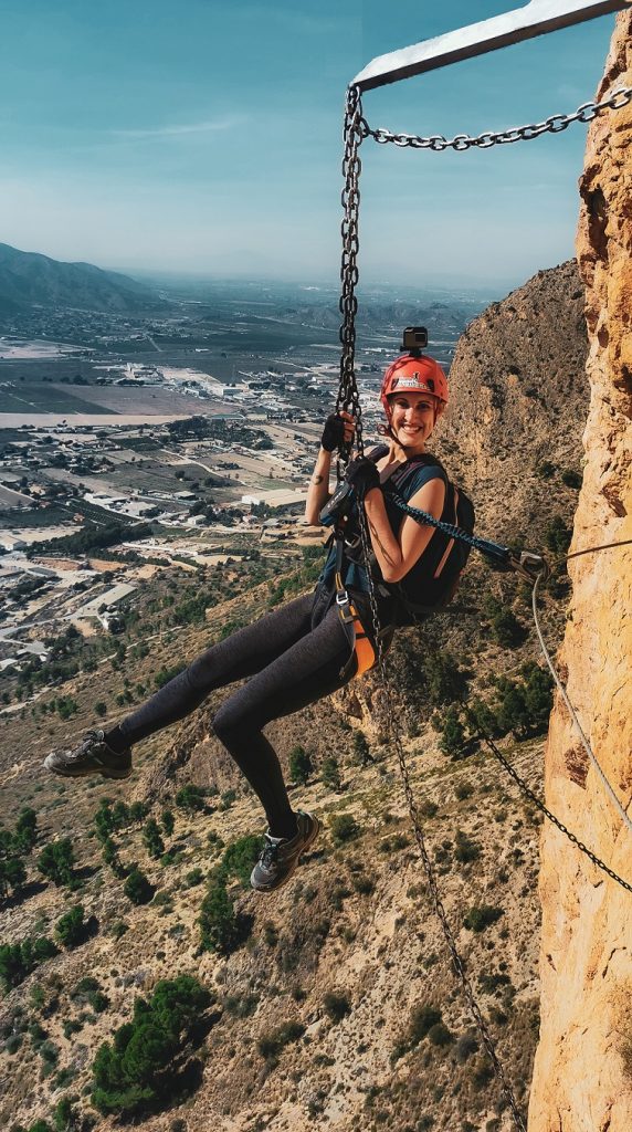 Amelia Carey Travel Spain hanging from a cliff